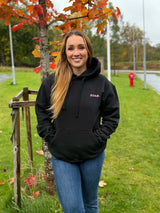 Svart assa.-hoody med rosa glittertrykk, vist på modell